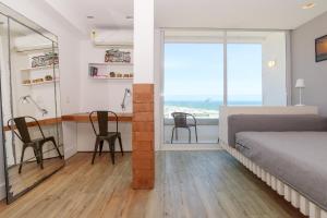 1 dormitorio con 1 cama, escritorio y sillas en Apartamento Barra Beach, en Río de Janeiro