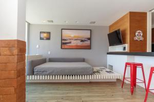 1 dormitorio con 1 cama y TV en la pared en Apartamento Barra Beach, en Río de Janeiro