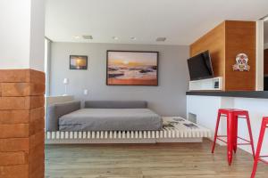 a bedroom with a bed and a tv on the wall at Apartamento Barra Beach in Rio de Janeiro