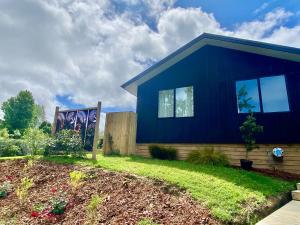 una casa blu con un giardino di fronte di Coatesville Country Retreat ad Auckland