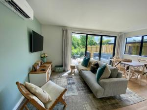 un soggiorno con divano e tavolo di Coatesville Country Retreat ad Auckland