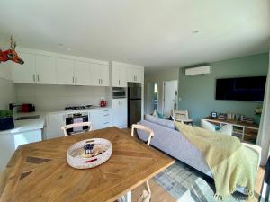 uma cozinha e sala de estar com uma mesa e um sofá em Coatesville Country Retreat em Auckland