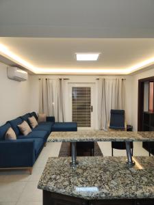 ein Wohnzimmer mit einem Sofa und einem blauen Sofa in der Unterkunft Dair Ghbar - Amman Apartment in Amman