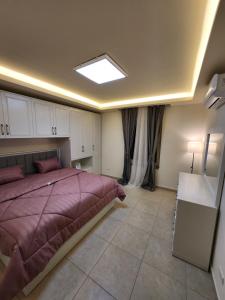 ein Schlafzimmer mit einem großen Bett und einem Fenster in der Unterkunft Dair Ghbar - Amman Apartment in Amman