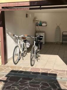 duas bicicletas estacionadas uma ao lado da outra numa garagem em Casa La Mo’ moderno bilocale in zona tranquilla em Cattolica