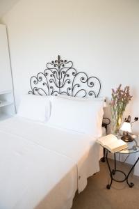 een slaapkamer met een wit bed met een metalen hoofdeinde bij Villa Dune di Scivu in Portixeddu