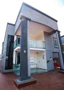 阿克拉的住宿－Elegant and Cosy Four Bedroom Home in Accra，前面有柱子的大建筑