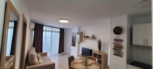 ein weißes Wohnzimmer mit einem Tisch und einer Couch in der Unterkunft Beach View Las Americas in Playa de las Americas + 38 Fotos