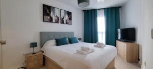 ein Schlafzimmer mit einem großen Bett, auf dem Handtücher liegen in der Unterkunft Beach View Las Americas in Playa de las Americas