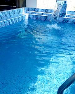 una persona en una piscina con una fuente de agua en Departamento de verano - CAMANA, en Camaná