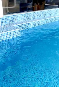 una piscina azul con azulejos azules. en Departamento de verano - CAMANA, en Camaná