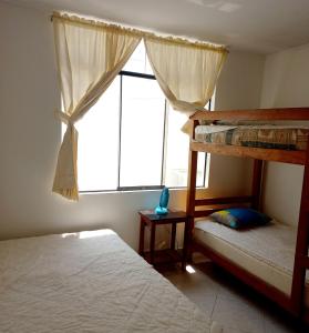 1 dormitorio con 2 literas y ventana en Departamento de verano - CAMANA, en Camaná