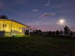 Una casa de noche con la luna en el cielo en Casa Villa Container, en Tibasosa