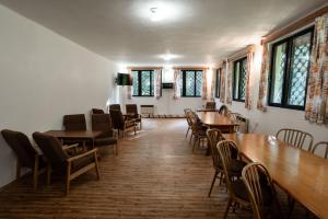 jadalnia ze stołami, krzesłami i oknami w obiekcie Penzion a Restaurace Kamínek w mieście Doksy