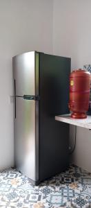 a stainless steel refrigerator on a counter with a red pot at Casa Flor de Dendê, Serra Grande, Bahia in Serra Grande