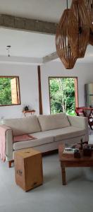 uma sala de estar com um sofá e uma mesa em Casa Flor de Dendê, Serra Grande, Bahia em Serra Grande