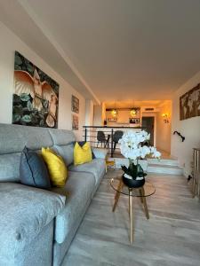 a living room with a couch and a table with flowers at La Casa M'SOL in Sant Feliu de Guixols