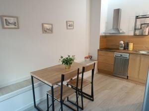 eine Küche mit einem Holztisch mit 2 Stühlen in der Unterkunft Apartamentos turisticos Ávila Puerta de la Santa 2-1 in Avila + 7 Fotos