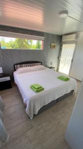 1 dormitorio con 1 cama grande y toallas verdes en Ampakiti Home, en Punta del Este
