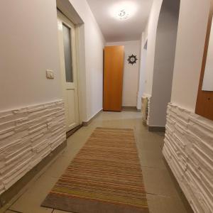 a hallway with a door and a rug at Apartament Atoosa cu vedere la munte in Sinaia