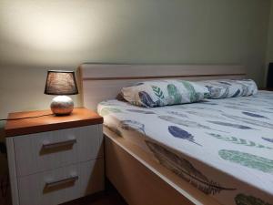een bed met een nachtkastje met een lamp erop bij Myslym Shyri lovely top apartment in Tirana