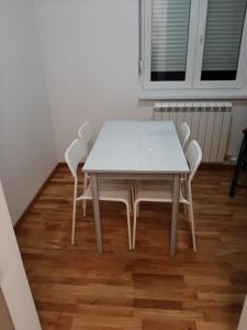 una mesa blanca y sillas en una habitación en Oaza Apartment Mirijevo, Free Garage Parking en Belgrado