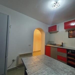 a kitchen with red cabinets and a counter top at Apartament Atoosa cu vedere la munte in Sinaia