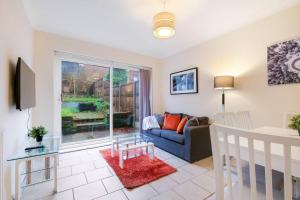a living room with a couch and a window at 4 Bedroom High Wycombe Home With Free Parking Free WiFi Private Garden - Great Transport Links! in Buckinghamshire