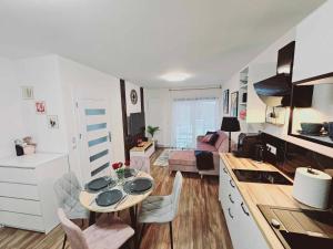 cocina y sala de estar con mesa en una habitación en Apartament Rose, Osada Górska, en Szklarska Poręba