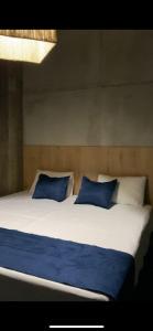 1 cama grande con 2 almohadas azules en Muladar Luxury en Filandia