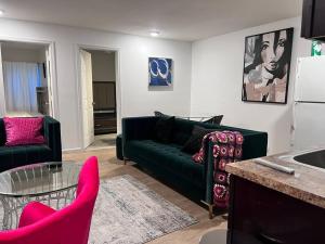 een woonkamer met een groene bank en roze stoelen bij Spacious secluded Big 2 Kings near EWR/Newark Downtown in Newark
