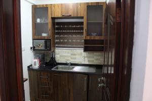 een kleine keuken met een wastafel en een koelkast bij KANS KRIB in Accra