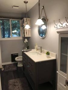 a bathroom with a sink and a toilet and a mirror at Steps to Beach, Fantastic Sunsets, Charming 3 bedroom Cottage in Ripley