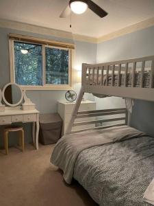 a bedroom with a bunk bed and a desk at Steps to Beach, Fantastic Sunsets, Charming 3 bedroom Cottage in Ripley