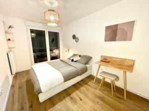 a bedroom with a bed and a wooden table at Bohemian Lodge Near Paris 8P Metro 14 in Saint-Ouen