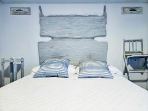 a bed with two blue and white pillows on it at Oak House Oakplacescom in León