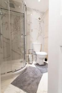 a bathroom with a toilet and a glass shower at Charming One-bed Flat in Dagenham