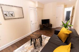 a living room with a couch and a tv at Charming One-bed Flat in Dagenham