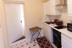 a small kitchen with a sink and a stove at Charming One-bed Flat in Dagenham