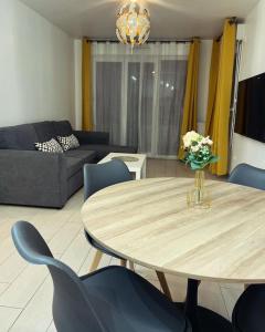 - un salon avec une table et des chaises bleues dans l'établissement Appartement Cosy, à Épinay-sur-Seine