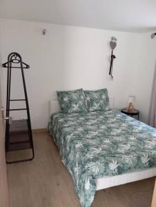 a bedroom with a bed and a cross on the wall at Appartement Cosy avec Jardin in Vaux-sur-Seine