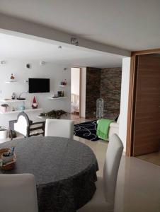 ein Wohnzimmer mit einem Tisch und weißen Stühlen in der Unterkunft Appartement Cosy avec Jardin in Vaux-sur-Seine