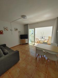 ein Wohnzimmer mit einem Sofa und einem Tisch in der Unterkunft Formentera Suite 8 in Es Pujols