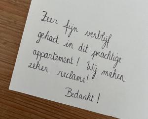 een stuk papier met een handschrift op een tafel bij Ruim en modern appartement ideaal gelegen tussen zee en jachthaven in Nieuwpoort