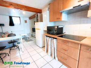 a kitchen with a counter and a table in it at ► BNB TOULOUSE ► Le Plaisant Maubec • WiFi • 24/7 in Plaisance-du-Touch