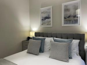 um quarto com uma cama com almofadas brancas e azuis em Peacock Guest House em Largs