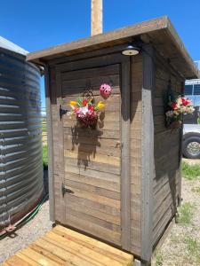 a wooden out house with flowers in it at JMA Granary in Riverton