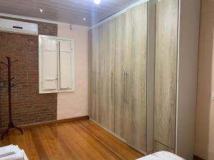 a bedroom with wooden cabinets and a brick wall at Casa de campo Quinta do Floriano in Teutônia