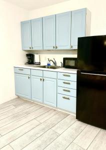 a kitchen with white cabinets and a black refrigerator at OCEAN VIEW Condo Daytona Beach in Daytona Beach