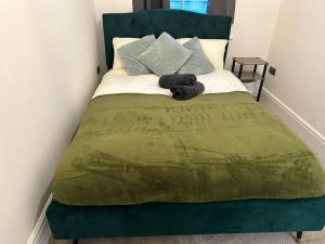 a green bed with a green blanket on it at 2 Bedroom Luxury Apartment by the Sea in Kent